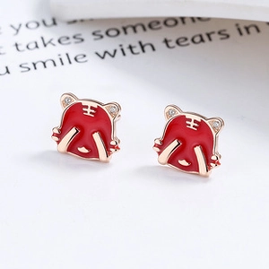 Macro detail of red enamel tiger earrings with rose gold plating and white zircon stones