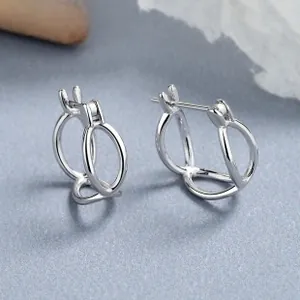 Detailed view of 925 sterling silver interlocking geometric hoop earrings on blue surface