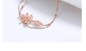 Detail of rose gold flower bracelet with sparkling cubic zirconia on delicate bead chain