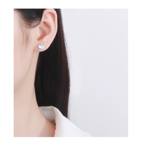 Close-up of classic 925 silver four-prong zircon stud earring worn on model ear
