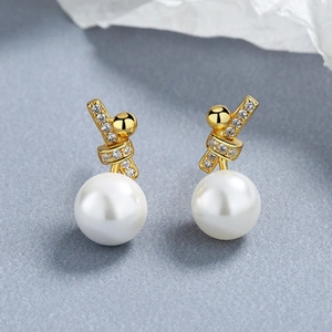 Detailed close-up of a French style pearl earring with gold twist design and zircon accents