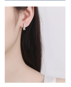 Close-up of minimalist 925 sterling silver rectangular earrings with pave zircons