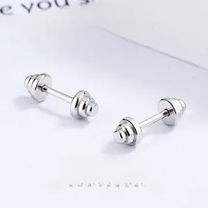 Macro view of silver dumbbell stud earrings with high-polish finish and screw-back design