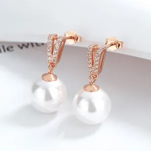 Close-up of S925 sterling silver bow earrings with round pearls and rose gold V-shaped accents