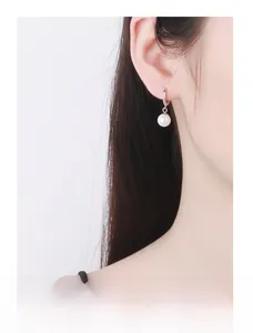 Close-up of elegant 925 silver hoop earrings with white pearls and sparkling pave diamonds