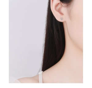 Gros plan d'une boucle d'oreille rose en argent sur un mannequin au design minimaliste