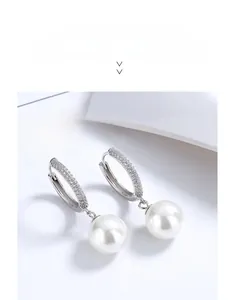 Close-up of S925 sterling silver hoop earrings featuring micro-pave crystals and white pearls