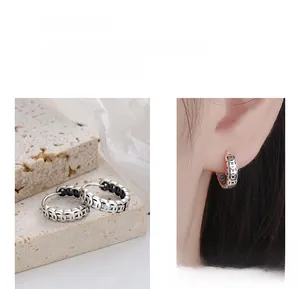 Détail des boucles d'oreilles créoles en argent 925 avec motif de pièce vintage