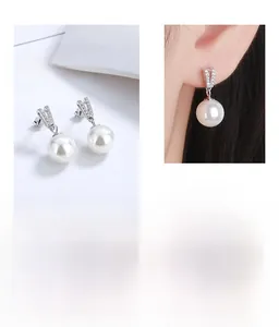 Détail de boucles d'oreilles en perles d'argent avec design en V et accents brillants