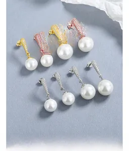 Dettaglio di orecchini con perle a goccia in oro, argento e rosa con micro-pave