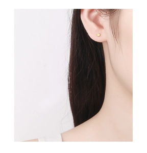 Close-up of a minimalist 925 silver gold-plated cylindrical stud earring on ear
