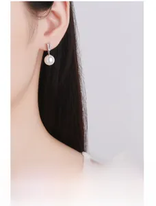 Gros plan de boucles d'oreilles perles avec crochets pavés de zircons sur mannequin