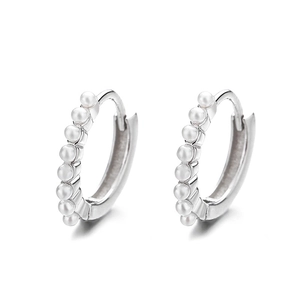 Elegante Creolen aus 925er Sterlingsilber mit kleinen weißen Perlen auf weißem Hintergrund
