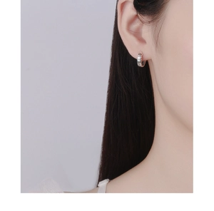 Gros plan d'une boucle d'oreille en argent 925 avec motif de pièce de monnaie évidé