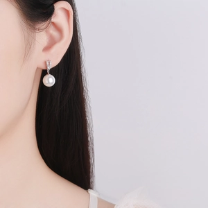 Boucles d'oreilles perles en argent 925 avec zircons portées par un mannequin chic