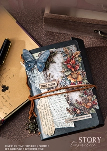 Vintage scrapbooking journal detail with floral collage, twine tie, and metal anchor pendant
