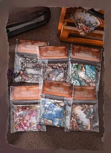 Flat lay of retro floral sticker packs with vintage scrapbooking supplies and dry flowers