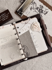 Nahaufnahme eines Vintage-Leder-Journal-Sets mit Kunstseiten und passendem Stift