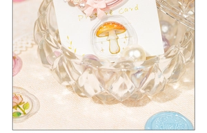 Detail of floral wax seal stickers on display card next to a crystal glass bowl