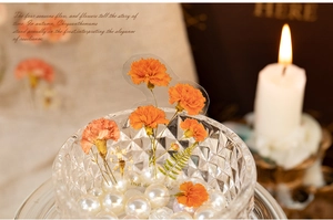 Detail of vintage orange floral PET stickers showcased in a decorative glass bowl with pearls