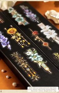 Macro shot of vintage floral PET stickers with gold foil details in a black gift box