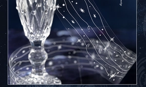 Close-up of white star and wave patterns on transparent PET tape around a glass