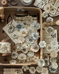 Macro shot of vintage fabric floral stickers and DIY scrapbooking materials in a tray