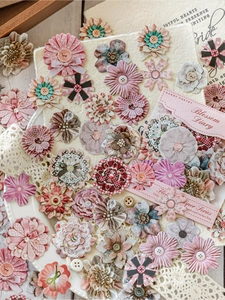 Detailed view of vintage fabric flowers and lace elements for DIY scrapbook decoration