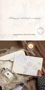 Detailed view of silver foiled envelope card with fireworks pattern and warm candle lighting