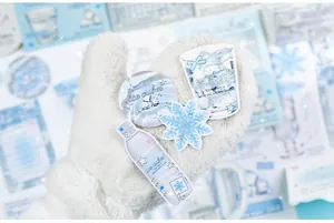 Close-up of winter snowflake themed PET stickers with ice blue patterns and glossy finish