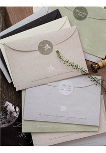 Macro detail of aesthetic envelopes with silver stamping and natural floral patterns