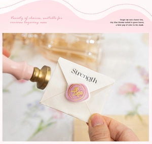 Détail du sceau en cire lavande avec motif abeille dorée sur mini enveloppe blanche