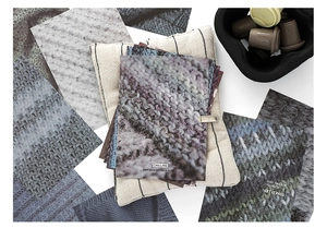 Close-up of decorative cards with knit textures and quotes on a cozy fabric background