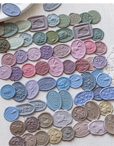 Flat lay of vintage 3D foam wax seal stickers in Morandi colors on white wood background