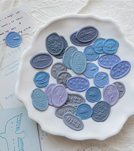 Macro detail of vintage PVC 3D wax seal stickers in cool tones and floral relief patterns