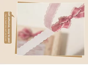 Detail showing self-adhesive pink lace tape with easy-tear edge for DIY scrapbooking