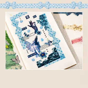 Detail of vintage blue bow ribbon stickers with butterfly and floral motifs on journal paper