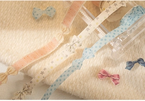 Detail view of vintage ribbon washi tapes with bow and star patterns for DIY journaling