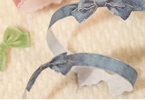 Close-up of decorative blue bow washi tape with die-cut edges for scrapbooking