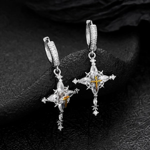 Detail of star-cross drop earrings with clear zircons on a textured black stone