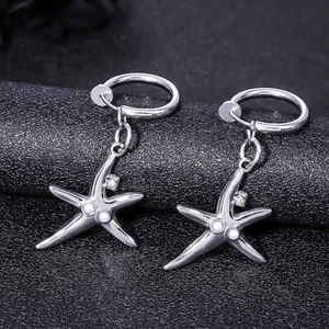 Détail de boucles d'oreilles clips étoile de mer avec perles et strass brillants