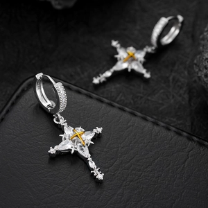 Detail of silver cross earrings featuring gold accents and inlaid white zircon stones
