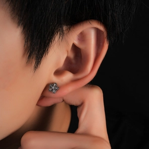 Macro view of flower stud earring in vintage black steel with sparkling zircon stones