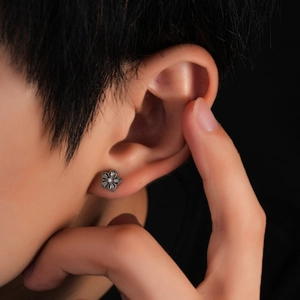 Vintage titanium steel flower stud earring with zircon inlay shown on ear