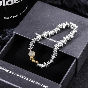 Close-up of industrial-style beaded bracelet with textured silver and gold metal beads