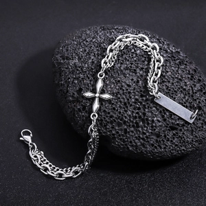 Detail of silver titanium steel layered bracelet with cross and tag on volcanic stone