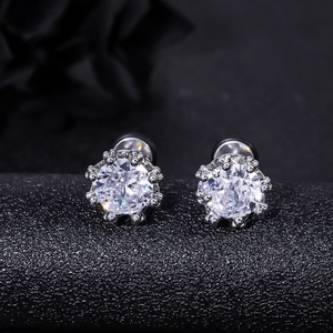 Macro shot of crown-setting silver stud earrings with sparkling round brilliant cubic zirconia
