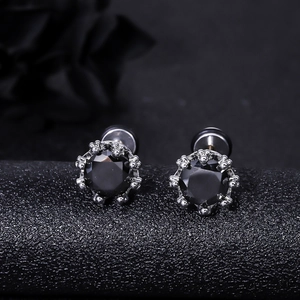 Macro shot of punk black zircon stud earrings with silver claw setting and screw back