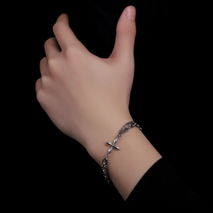 Close-up of a silver titanium steel four-leaf clover chain bracelet on a male wrist