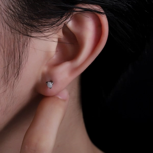 Minimalist silver dragon claw stud earring with round blue gemstone on ear for women